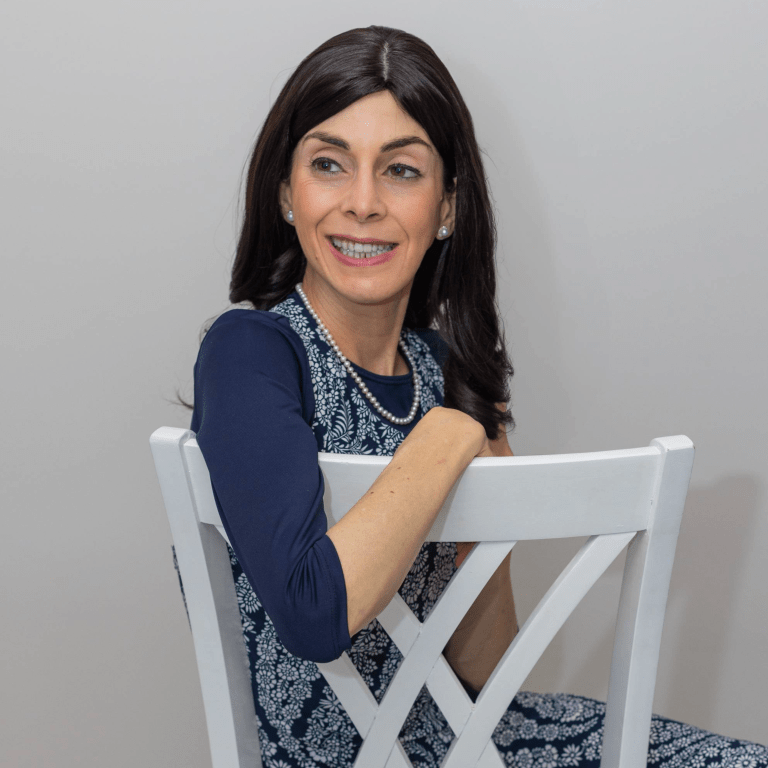 Chair-photo-for-Website-Final Devorah smiling sitting in a white chair